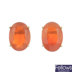 A pair of oval-shape fire opal single-stone stud earrings.