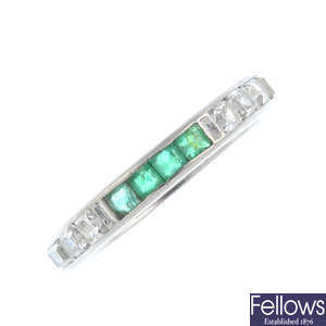 A mid 20th century emerald and diamond full eternity ring.