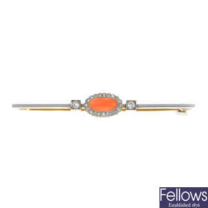 An early 20th century platinum and gold, coral and diamond bar brooch.