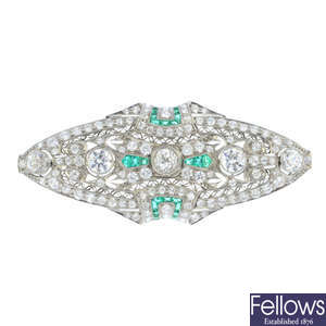 A diamond and emerald brooch.