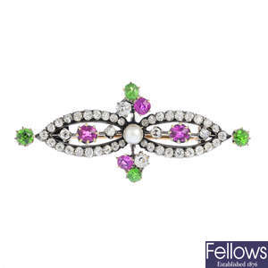 An Edwardian silver and 12ct gold, seed pearl, diamond, ruby and demantoid garnet brooch.