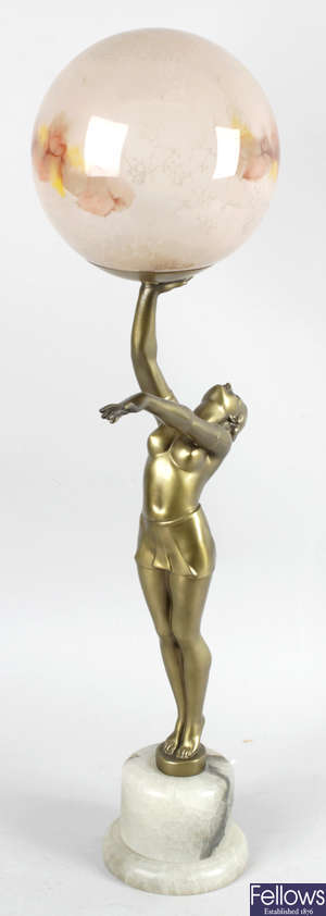 An Art Deco gilt spelter lamp modelled as a standing semi naked female.