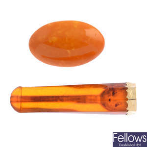 An early 20th century gold amber cheroot and a natural amber brooch.