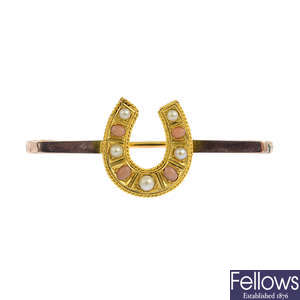 An early 20th century 9ct gold coral and split pearl horseshoe bar brooch.
