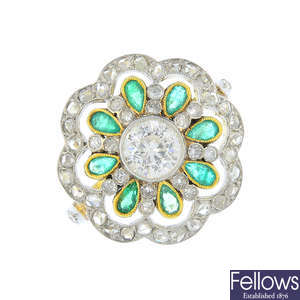 A diamond and emerald floral cluster ring.