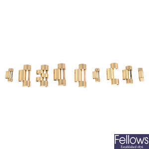 ROLEX - a group of seven yellow metal bracelet links and yellow metal spring bars.