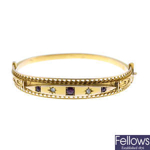 An early 20th century 9ct gold ruby and diamond hinged bangle.