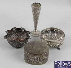 An Eastern white metal bud vase of trumpet form, a similar small bowl with frilled collar, trinket box with removable pin cushion top, etc. (4).