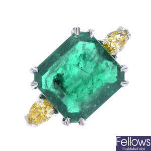 An emerald and 'yellow' diamond three-stone ring.
