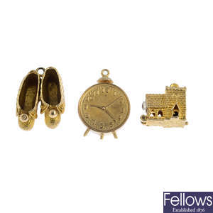 Three 9ct gold charms, fob, padlock clasp and a ring.
