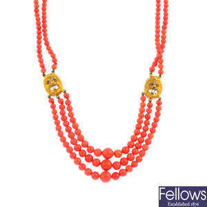 A coral, ruby and diamond Greek theatre mask necklace.