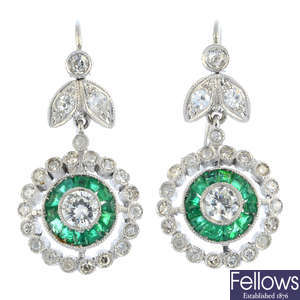 A pair of diamond and emerald earrings.