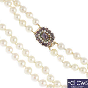 A cultured pearl two-row necklace, with garnet and split pearl clasp.