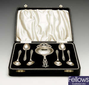 A matched 1930's cased set of six silver teaspoons and a tea strainer.