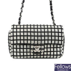 CHANEL - a black and white woven New Mini Flap handbag.
