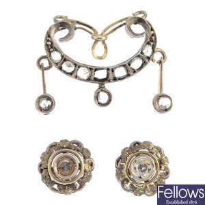 A diamond pendant and earrings.