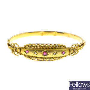 An early 20th century 9ct gold garnet-topped-doublet and diamond hinged bangle.
