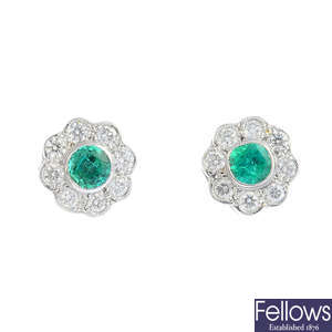A pair of emerald and diamond floral cluster earrings.