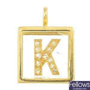 An 18ct gold cube pendant with diamond 'K' initial.