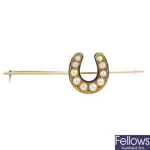A gold split pearl and enamel horseshoe brooch.