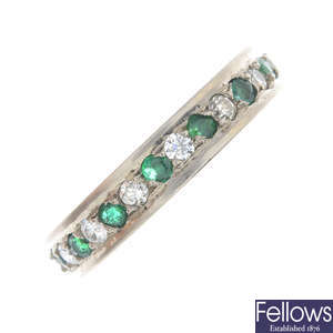An 18ct gold diamond and emerald full eternity ring.