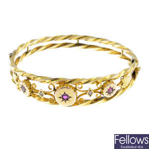 An Edwardian 9ct gold ruby and diamond hinged bangle.