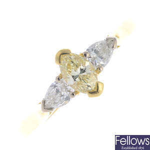 An 18ct gold coloured diamond and diamond three-stone ring.
