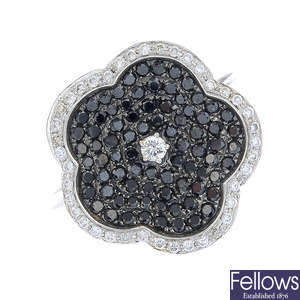An 18ct gold diamond and black gem floral cluster ring.