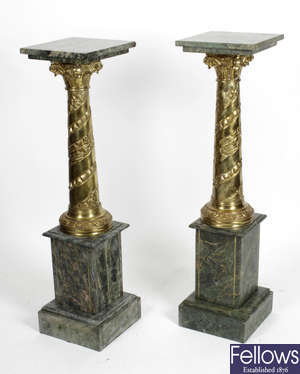 A pair of reproduction gilt metal and green marble torchere pedestal stands.