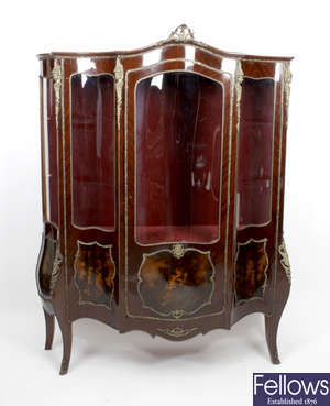 A 20th century stained wooden French style bombe shaped display cabinet.