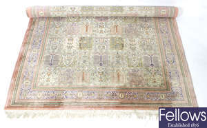 A 20th century machine woven silk work rug, the whole of floral multi panel design on a pink coloured ground.
