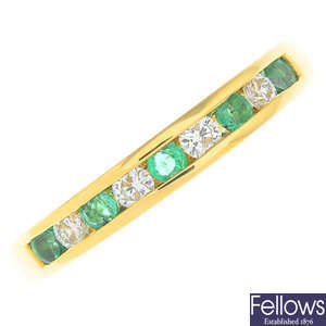 An 18ct gold emerald and diamond half eternity ring.