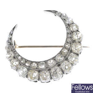 A late Victorian silver and gold diamond crescent brooch.
