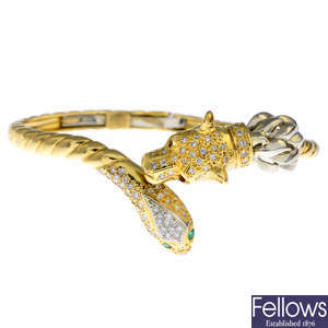An 18ct gold, diamond, ruby and emerald lion and snake hinged bangle.