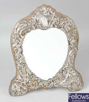 An Edwardian silver mounted heart shape mirror with easel back.