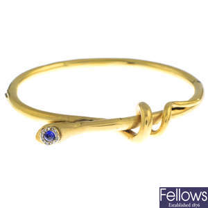 A late Victorian gold, sapphire, diamond and ruby snake bangle.