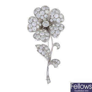 A gold diamond flower brooch.