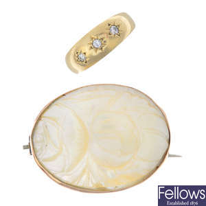 A 9ct gold diamond three-stone ring and a mother-of pearl brooch.