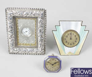 An Art Deco sterling silver and enamelled dressing table clock, a small 925 silver cased travel clock, and a Victorian dressing table clock.