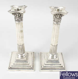 A pair of Edwardian silver mounted Corinthian column candlesticks.