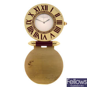 A gold plated travel clock by Cartier.