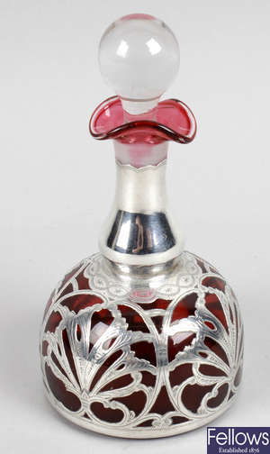 An early 20th century cranberry glass and silver overlaid scent bottle and stopper.