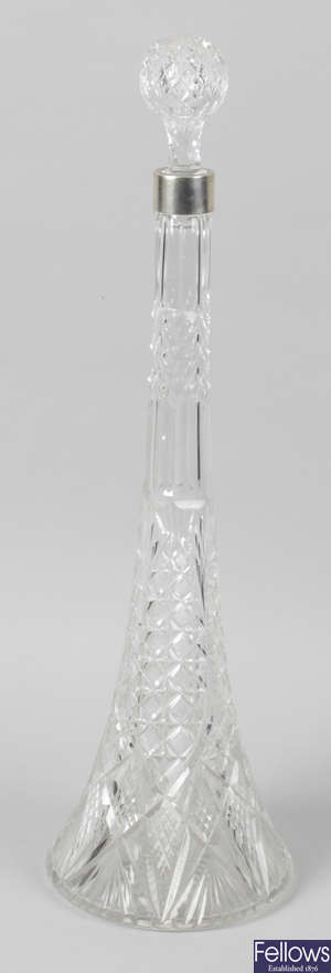 A large cut glass clear bottle, with white metal banded collar.