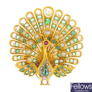 An early 20th century gold, emerald, split pearl and diamond peacock brooch.