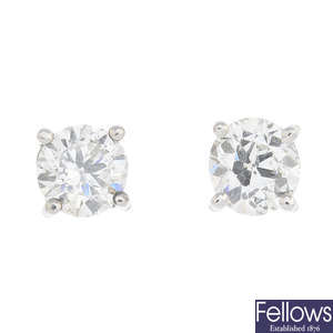 A pair of circular-cut diamond stud earrings.