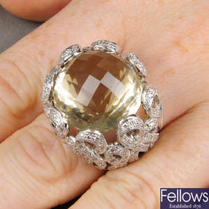 A multifaceted citrine dress ring, with diamond crossover loop surround.