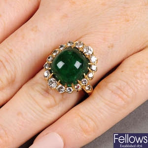A Colombian emerald cabochon and circular-cut diamond cluster ring.
