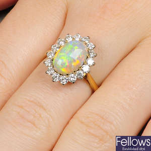 An 18ct gold oval opal cabochon and brilliant-cut diamond cluster ring.