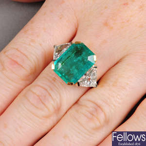 A Colombian emerald ring, with modified triangular-shape diamond sides.