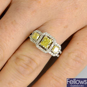 A Fancy Intense yellow diamond and 'yellow' diamond three-stone ring, with brilliant-cut diamond surrounds.